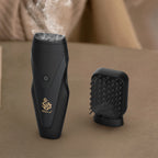 Black electric hair bakhoor diffuser with comb-style heat plate, vapor rising from top