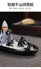 Tower backflow incense burner side view with white cone and smoke over black tray