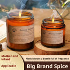 Two amber scented candles in glass jars, both lit with visible wicks and wax