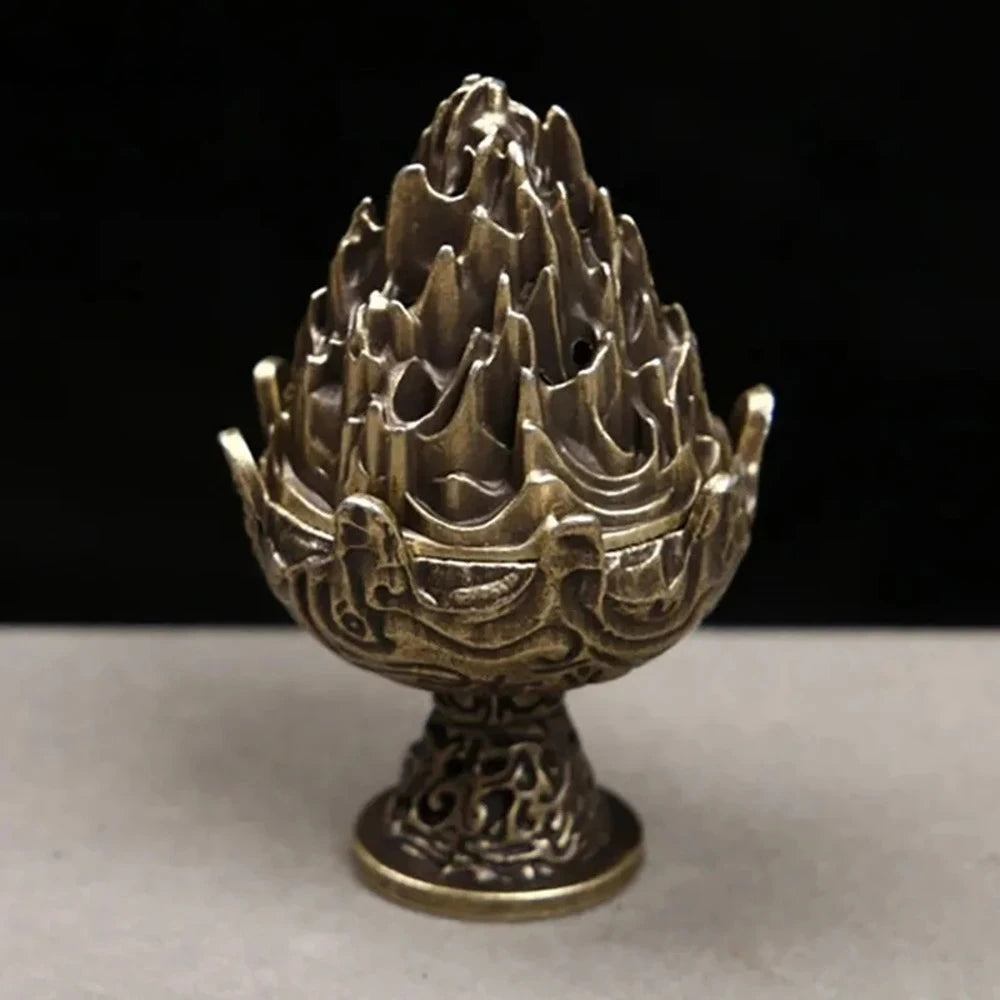 Copper-toned incense censer close-up with carved flame-lotus top and decorative pedestal base.