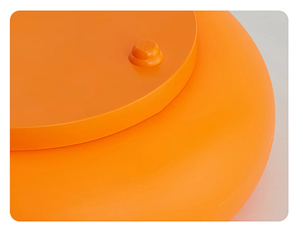 Orange donut table lamp, side view with small top button and curved top rim