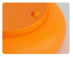 Orange donut table lamp, side view with small top button and curved top rim