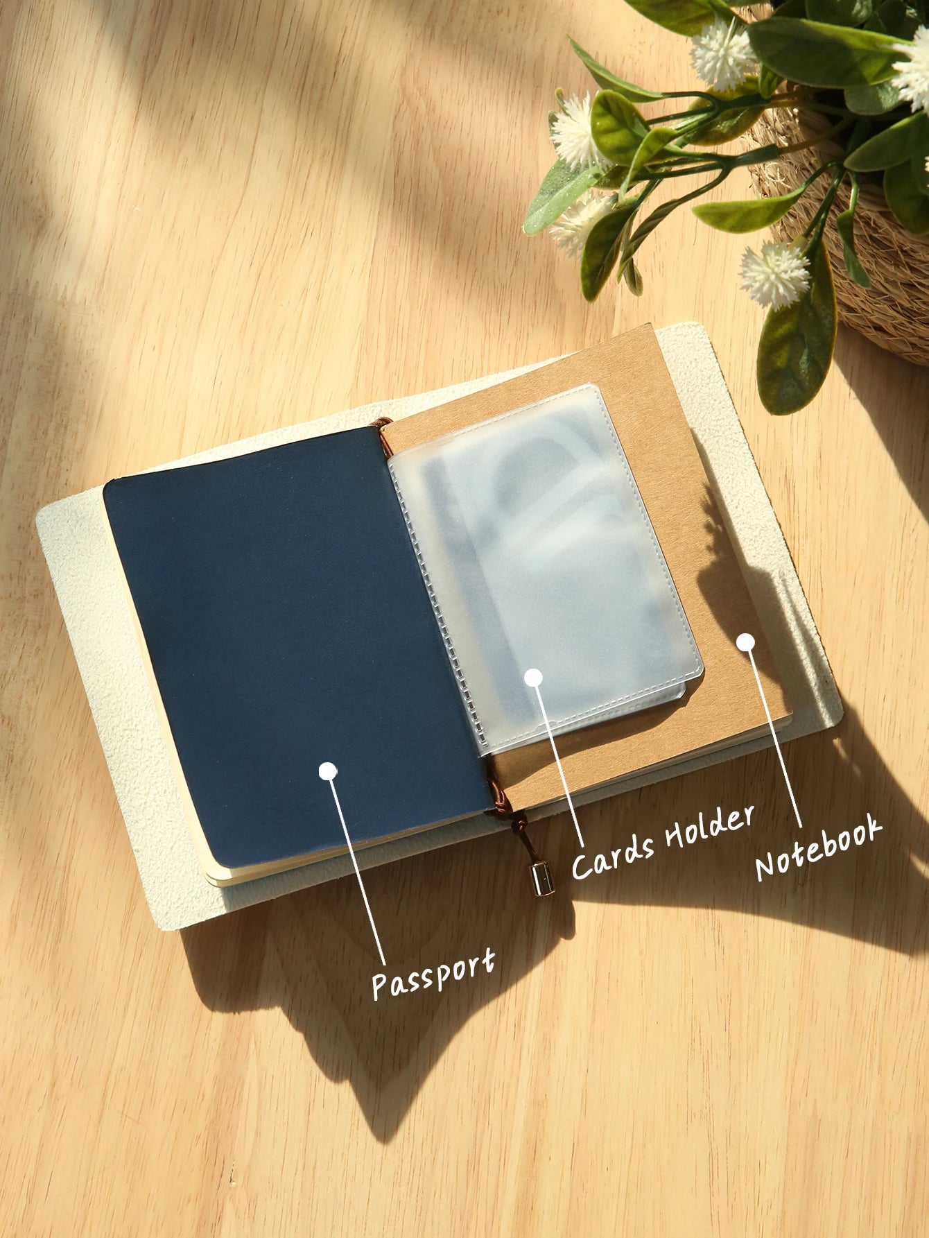 Open passport holder with dark cover, card sleeve, and light blue notebook insert