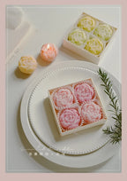 Rose-scented candle gift box with pink rose-shaped candles and a few lit candles