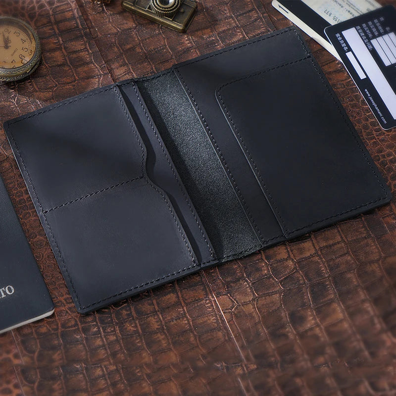 Obsidian black passport wallet opened with two card pockets on left and one large right slot