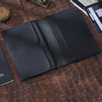 Obsidian black passport wallet opened with two card pockets on left and one large right slot