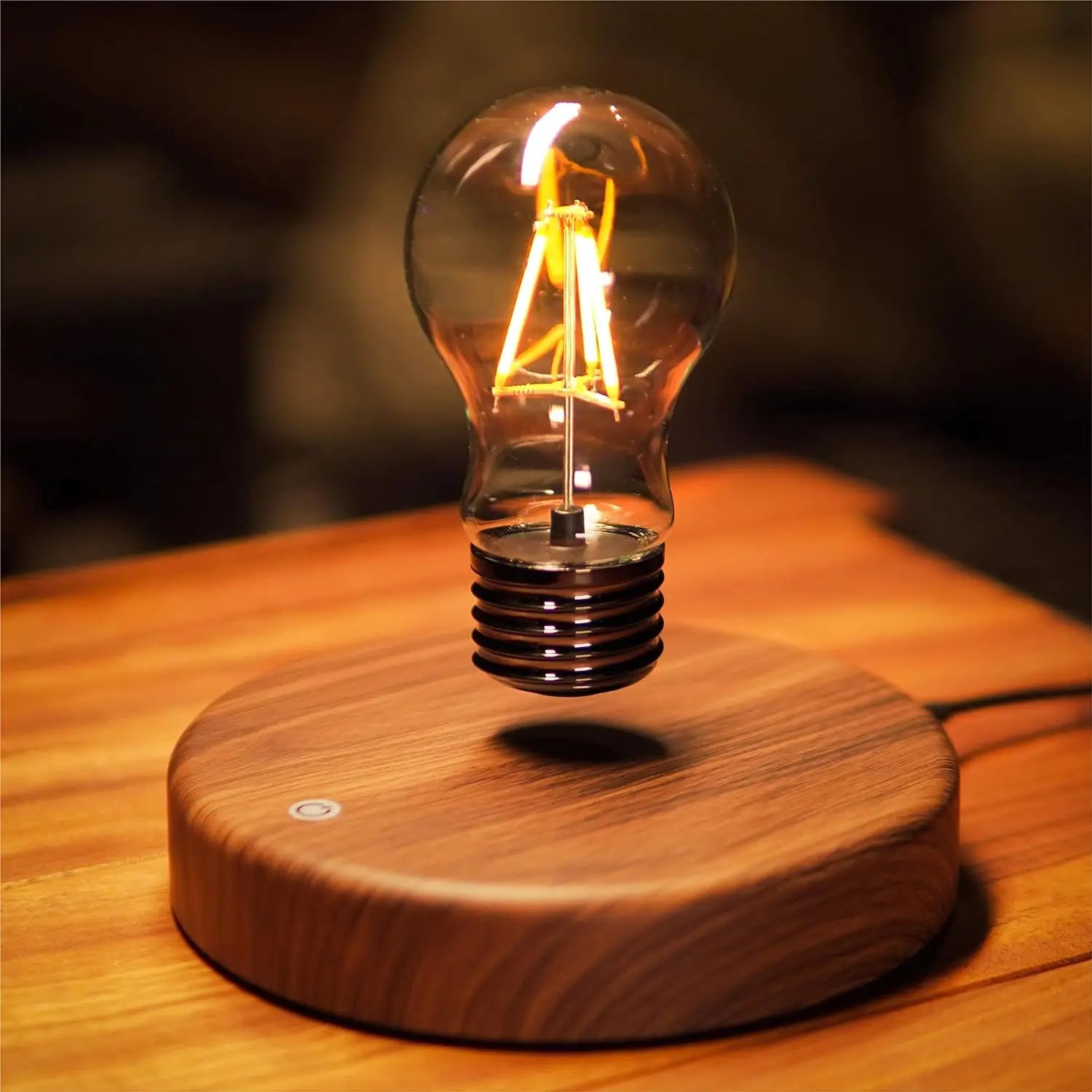 Levitating magnetic LED night lamp with glowing bulb on round wood-look base