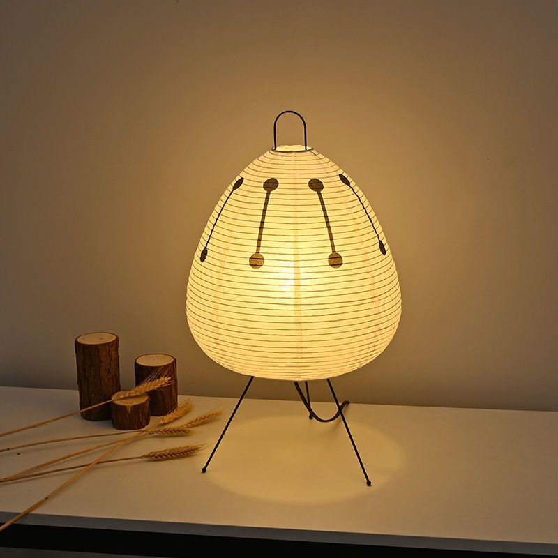 Warm glowing paper lantern shade with black dotted line accents and tripod stand