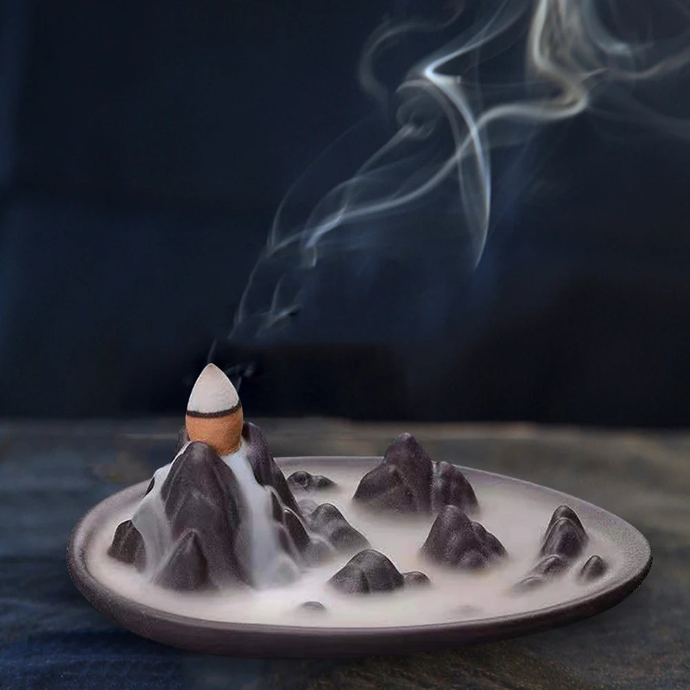 Backflow incense cone refill set on a wide burner plate, smoke rising from cones