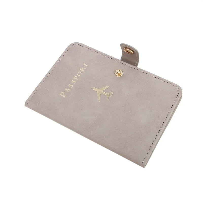 Slate gray passport cover with “PASSPORT” text, airplane emblem, and snap tab