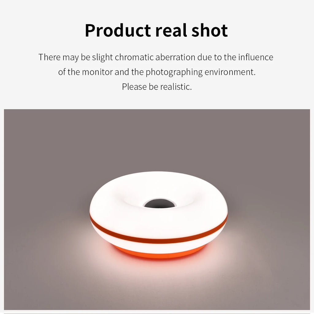 White donut table lamp with amber glow from center, orange outer rim.