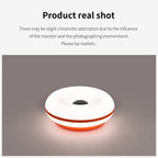 White donut table lamp with amber glow from center, orange outer rim.