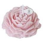 Peony sculptural candle, close-up of pale pink flower with lit white wick