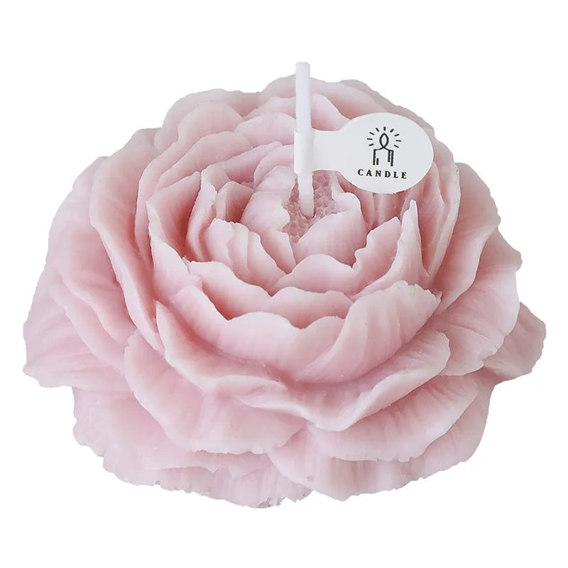 Peony sculptural candle, close-up of pale pink flower with lit white wick