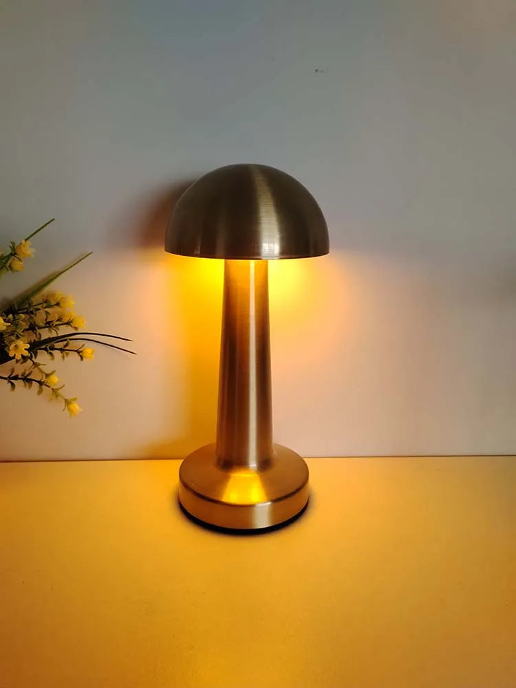 Brushed gold LED table lamp with domed shade and round base, warm glow
