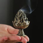 Boshan-style incense burner on a small pedestal, bronze-and-gold finish with smoke.