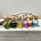 Glass car perfume diffuser: assorted colored bottles with wooden ball caps and braided cords