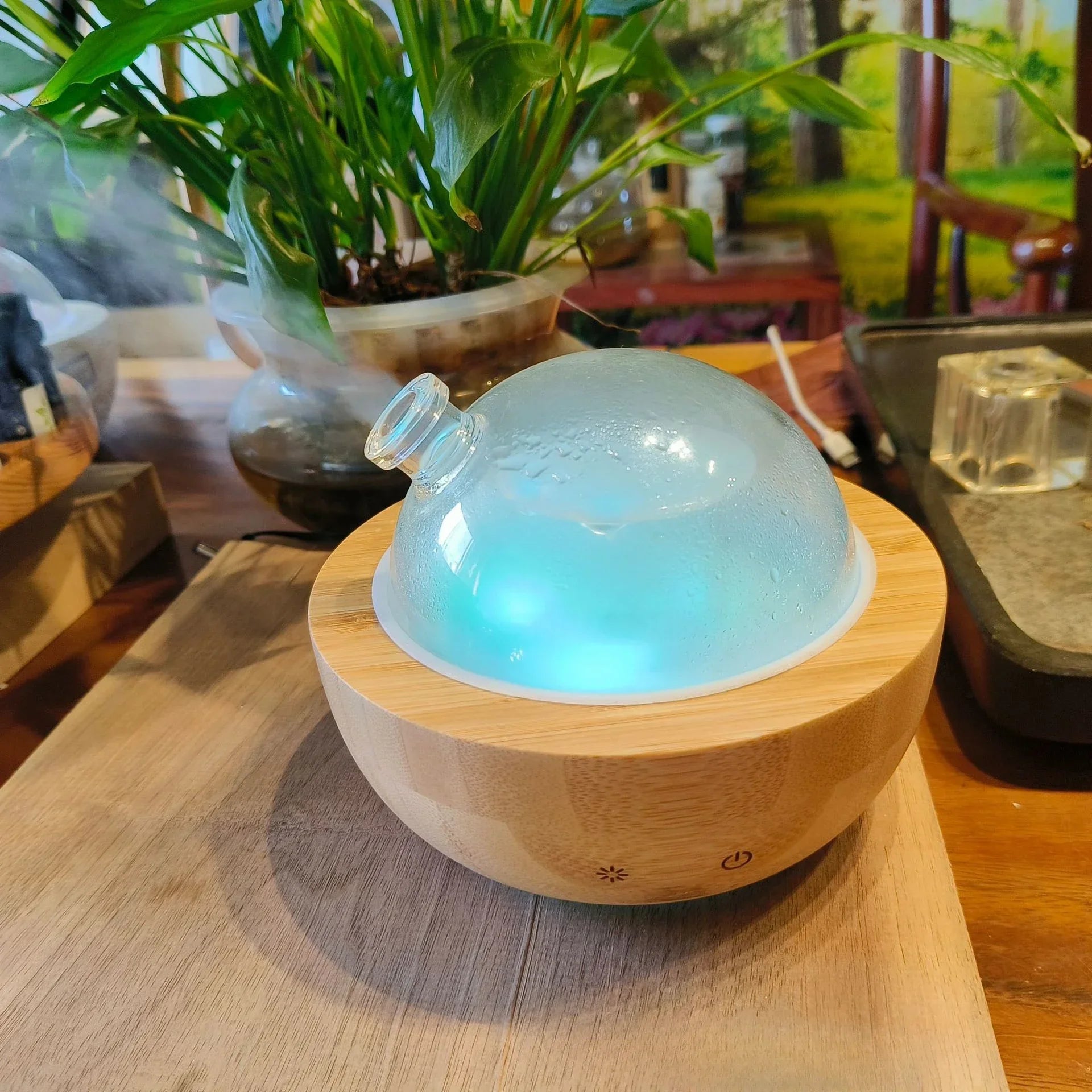 Luxe glass dome aroma diffuser on Natural Wood base, blue glow light inside