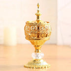 Gold Arabic-style incense burner with ornate lattice sides and faceted crystal stand