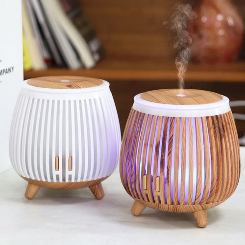 Wood-grain aroma diffuser humidifier with white base, striped sides, and mist output