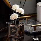 Square mini reed diffuser bottle with black reeds and white flower heads on marble, 50ml
