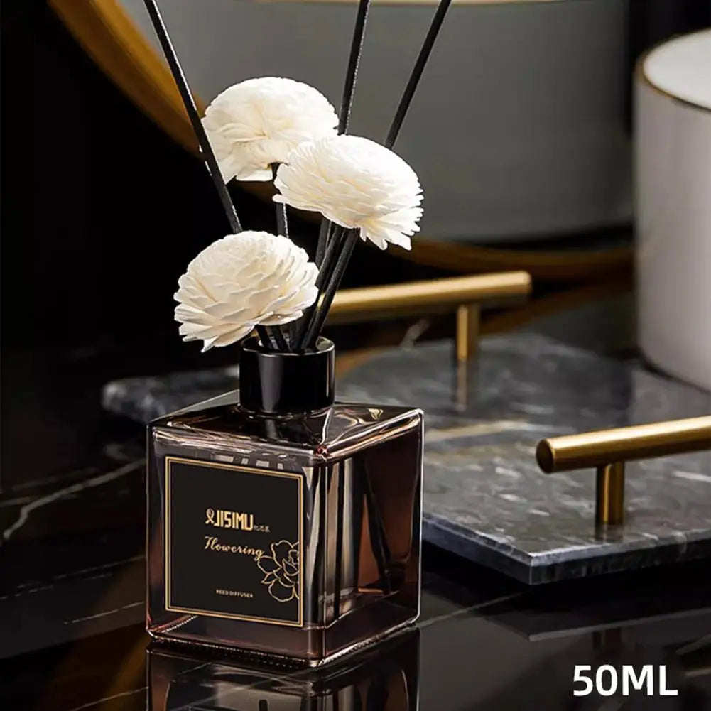 Square mini reed diffuser bottle with black reeds and white flower heads on marble, 50ml