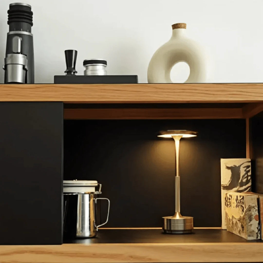 Cordless touch reading lamp in warm brass-gold on a wood shelf