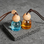 Glass car perfume diffuser: blue and amber bottles with wooden ball caps and cords