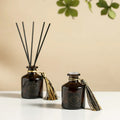 Reed diffuser set: two 50ml dark bottles with reeds and gold tassel accents