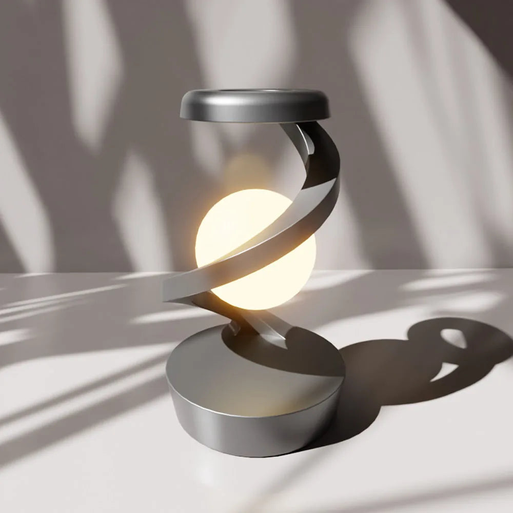 Silver wireless charging atmosphere lamp glowing on a tabletop with a round base.