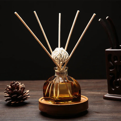Amber glass reed diffuser with white reeds, woven resin ball topper, round wooden base