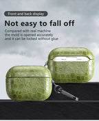 Emerald green crocodile-grain AirPods case showing front latch and keychain clip.