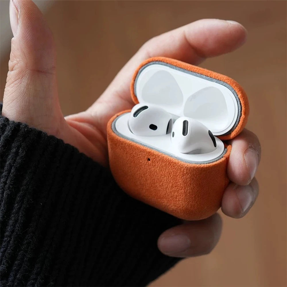 Amber orange Alcantara AirPods case with open lid and white AirPods inside