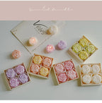 Rose-scented candle gift set with assorted pastel rose candles in open boxes