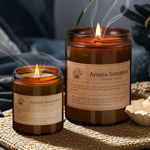 Amber glass scented candle jar with lit wick and printed label