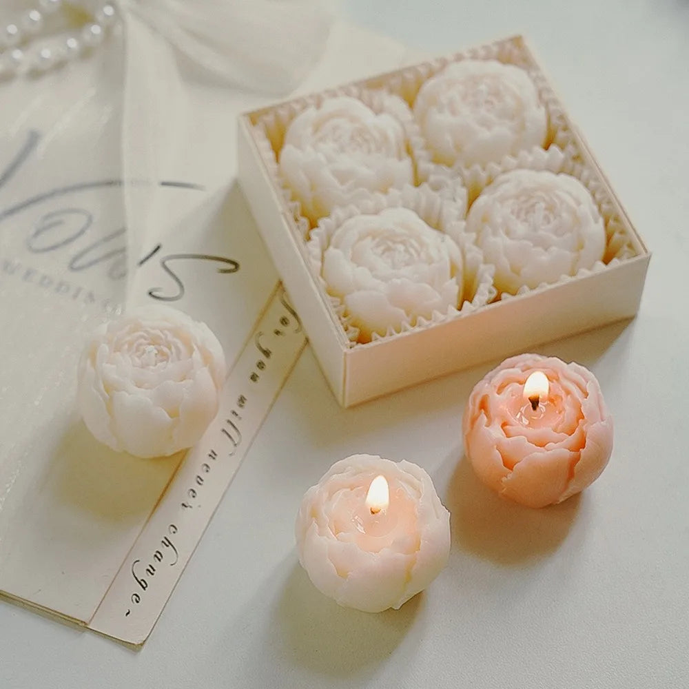 Rose-scented candle gift box with white rose-shaped candles and one lit candle