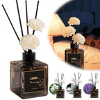 Reed diffuser bottle with black reeds and white flowers beside a smaller set display