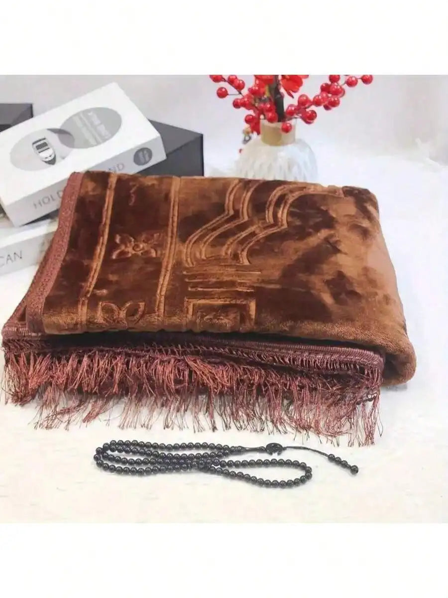 Velvet padded prayer rug in brown with raised arch pattern and long dark fringe along bottom edge.