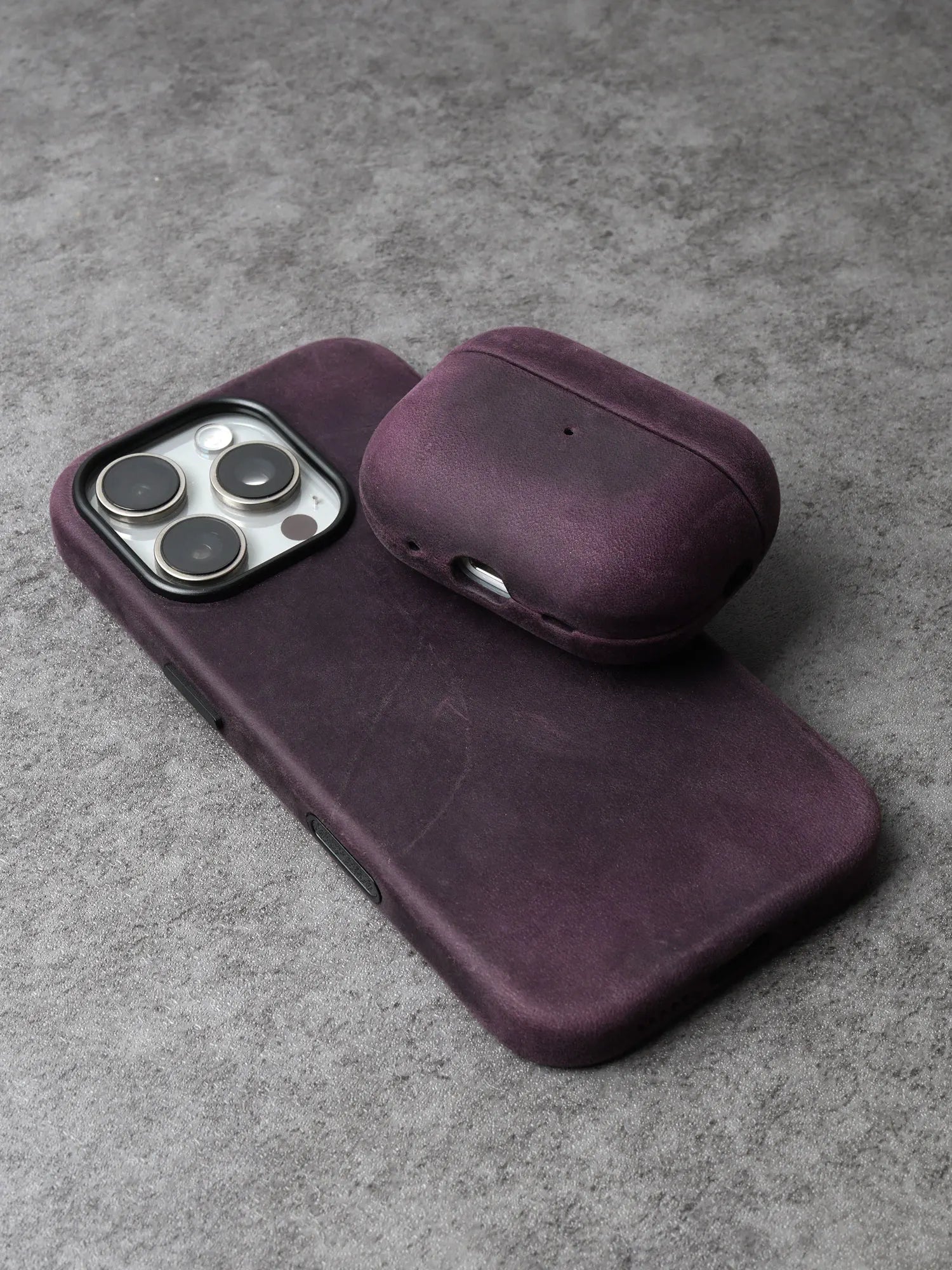 Purple leather AirPods case with curved lid and bottom port cutout