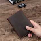 Compact travel document wallet, dark brown leather, closed with contrast stitching