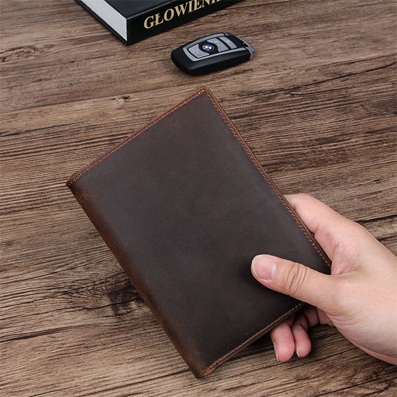 Compact travel document wallet, dark brown leather, closed with contrast stitching