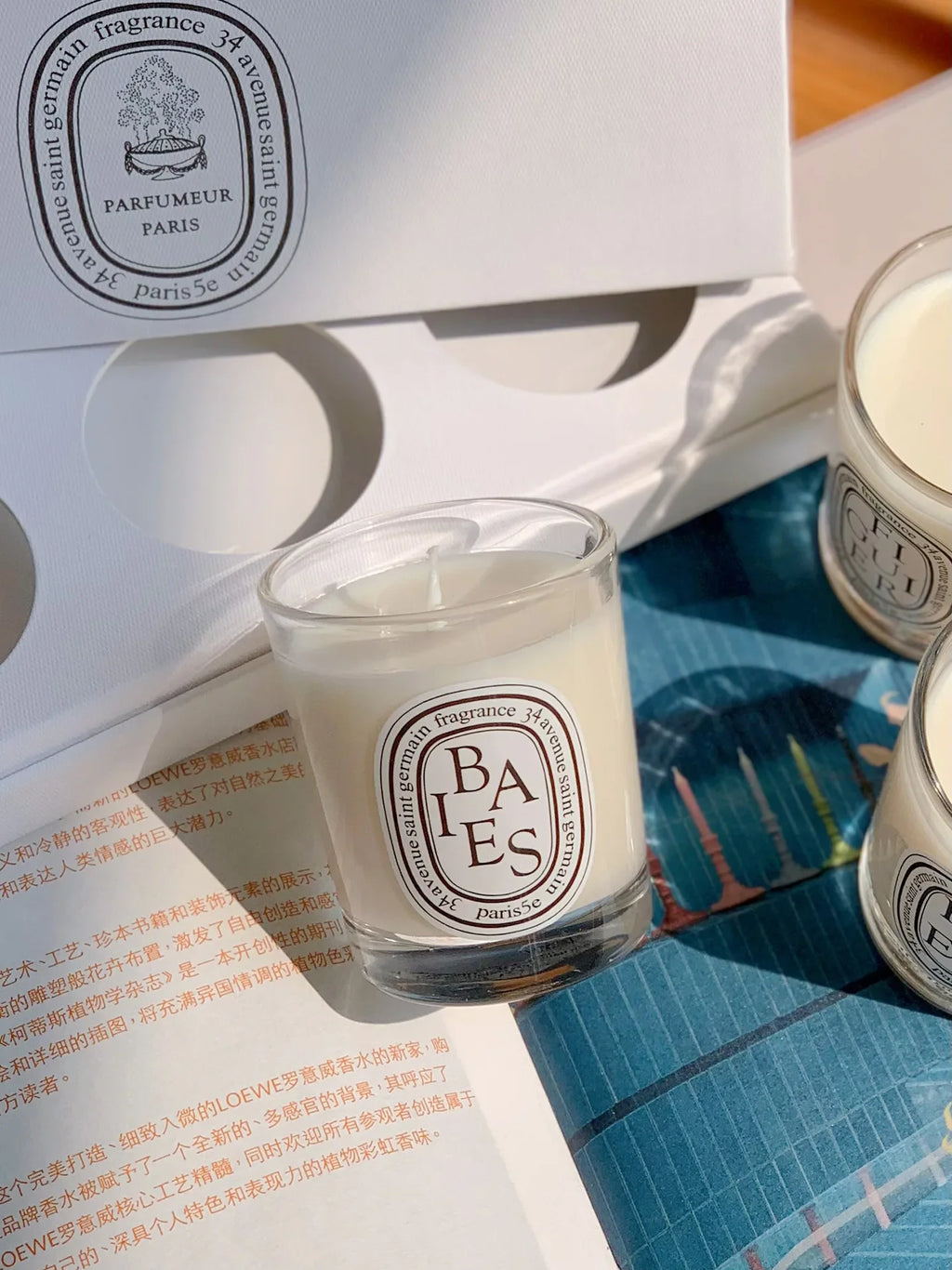 Duftkerze im Glas mit „BAIES“-Etikett
