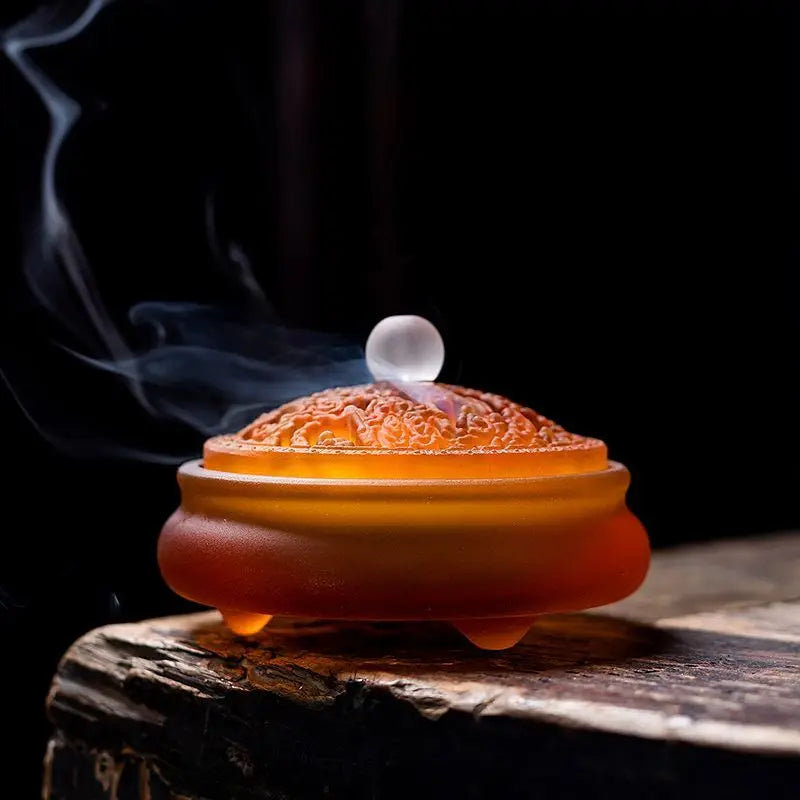 Crimson glass incense vessel with carved lid detail and rising smoke
