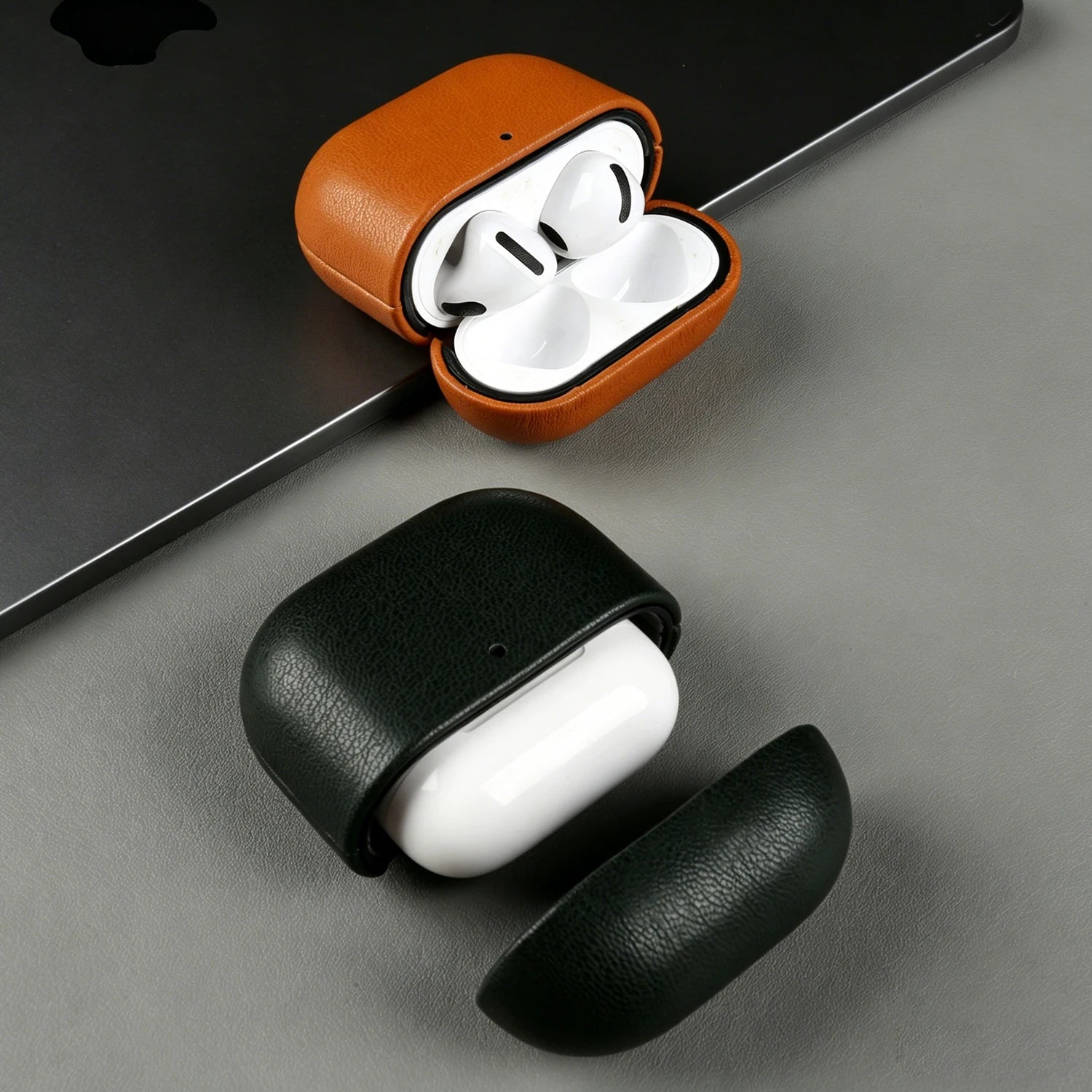 Warm brown eco leather AirPods case with earbuds, open lid, plus closed dark green case