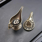 Two cone incense burner holders with engraved medallions and ornate metalwork