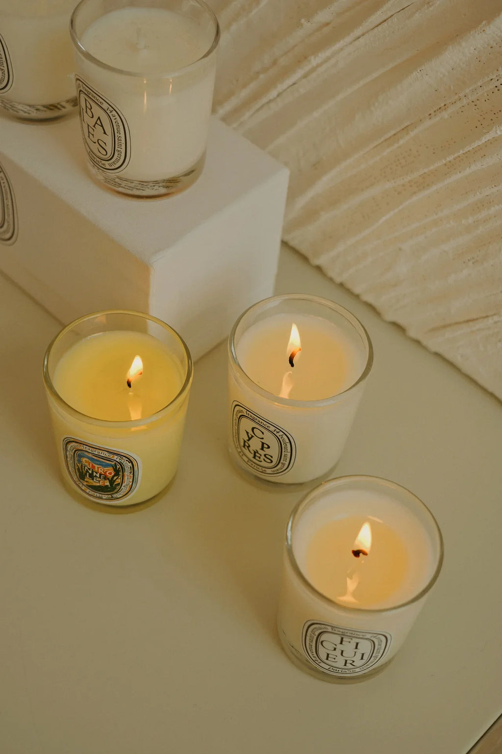 Bougies parfumées 190 g en verres, vues de dessus, 4 flammes allumées.