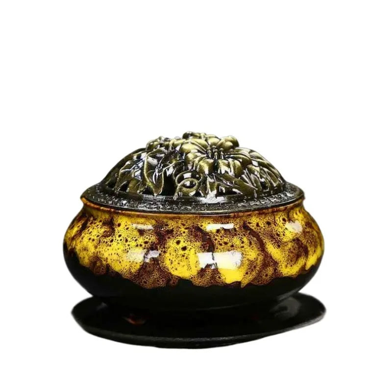 Ceramic incense burner with amber speckled glaze and ornate gold lid