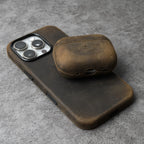 Olive-brown leather AirPods case with rounded lid and side charging cutout