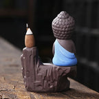 Backflow incense burner side view, Buddha figure with blue robe and incense cone