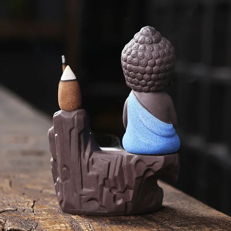 Backflow incense burner side view, Buddha figure with blue robe and incense cone